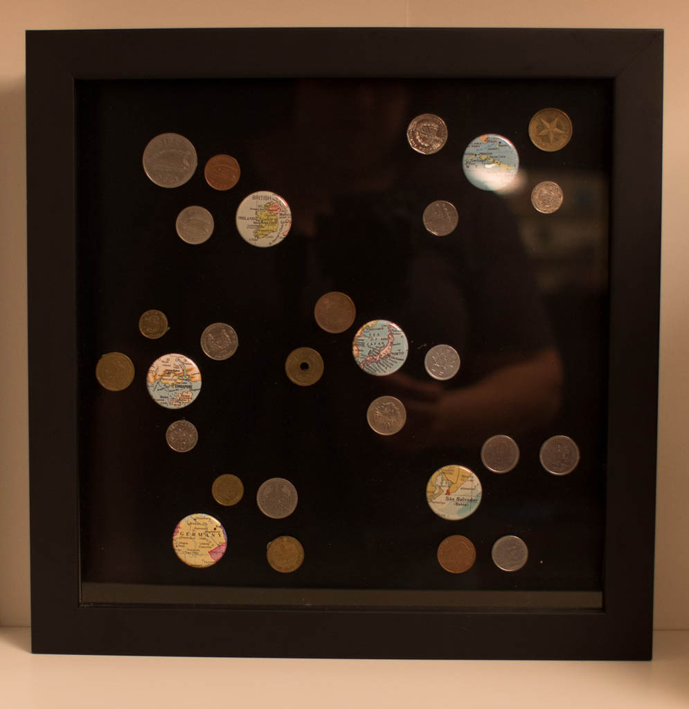 Shadowbox displaying foreign coins from travels