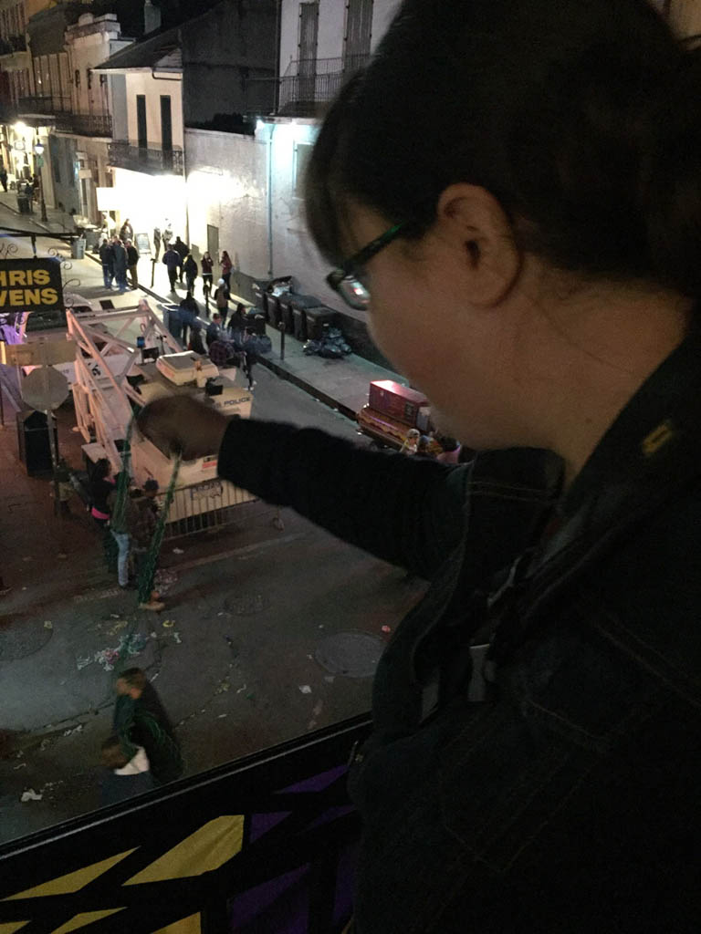 Me throwing beads from balcony during Mardi Gras