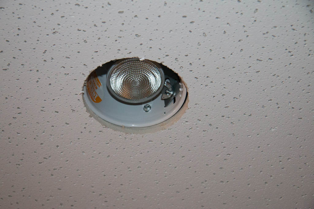 Recessed lighting housing in ceiling tile without trim piece